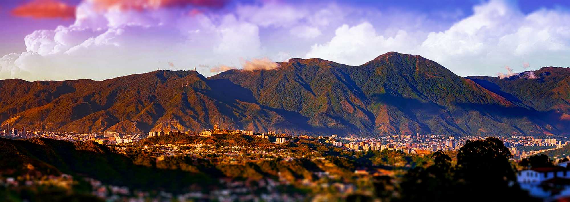 Caracas Cityscape with Mountain Backdrop A panoramic view of Caracas, Venezuela, nestled against dramatic mountain ranges under a vibrant